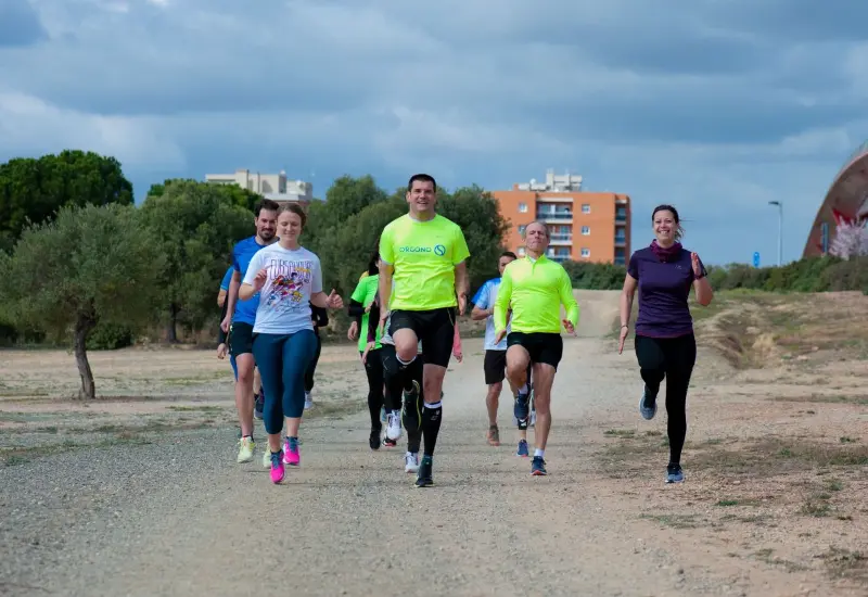 Grup del club corrent per un camí de terra a plena llum del dia